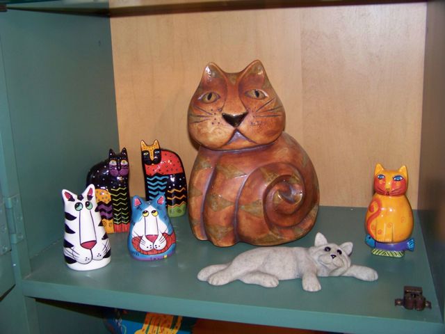 Multiple cat figurines in hutch